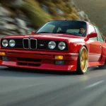 BMW E30 rouge sportive sur route, en pleine accélération