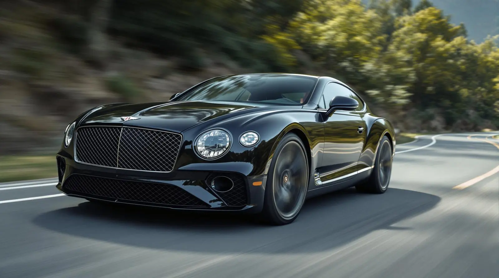 Bentley Continental GT noire roulant sur route sinueuse au soleil